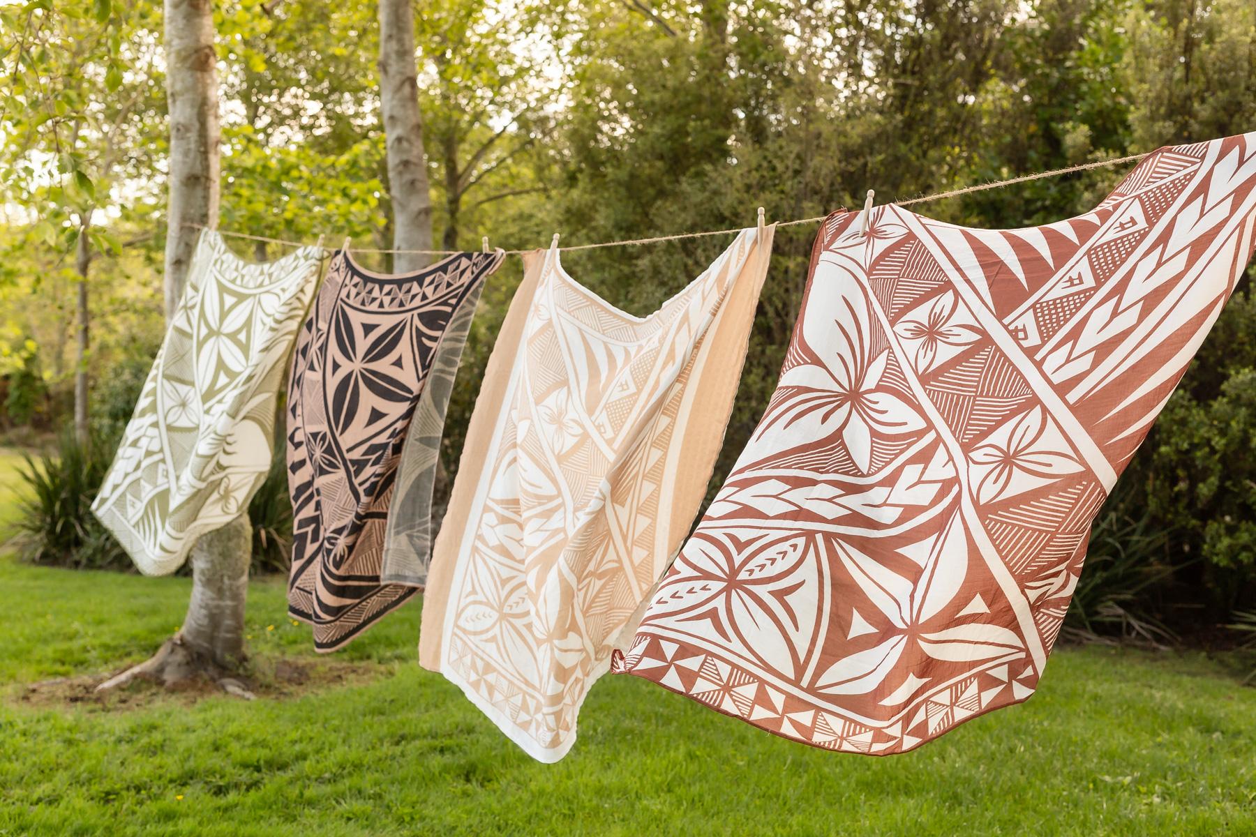 Four Polynesian styled baby wraps hanging outside on a washing line