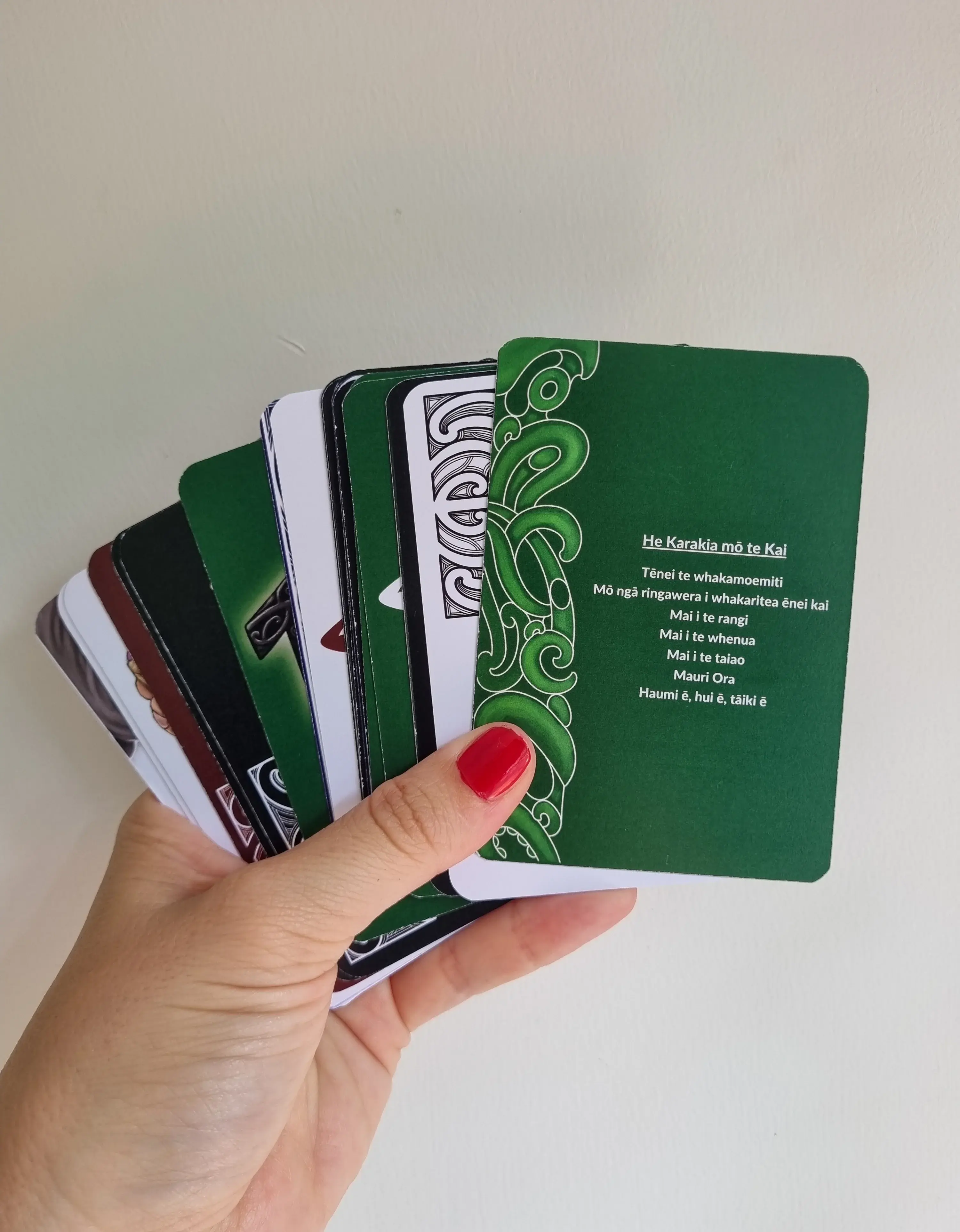 Hand holding Māori card set