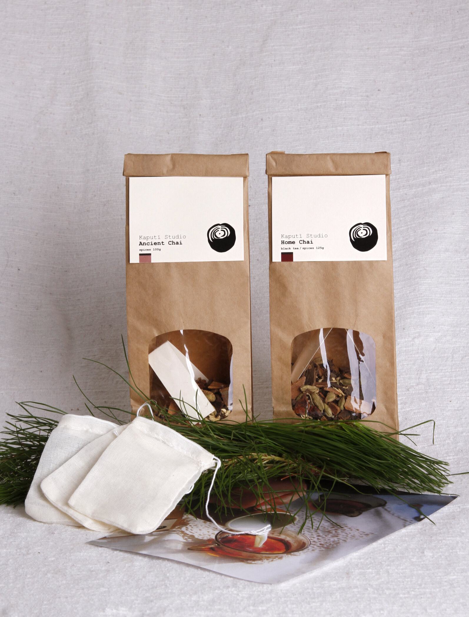 Two brown bags of loose leaf tea in front of a white background