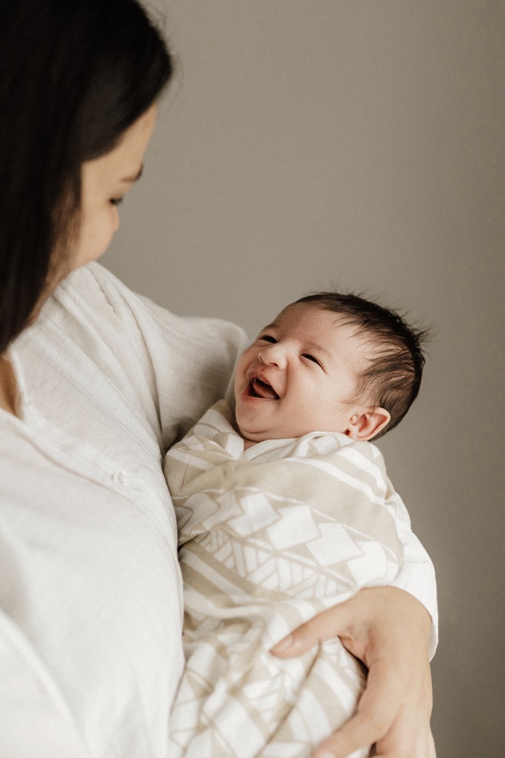 Mother and laughing baby wrapped in polynesian inspired baby wrap