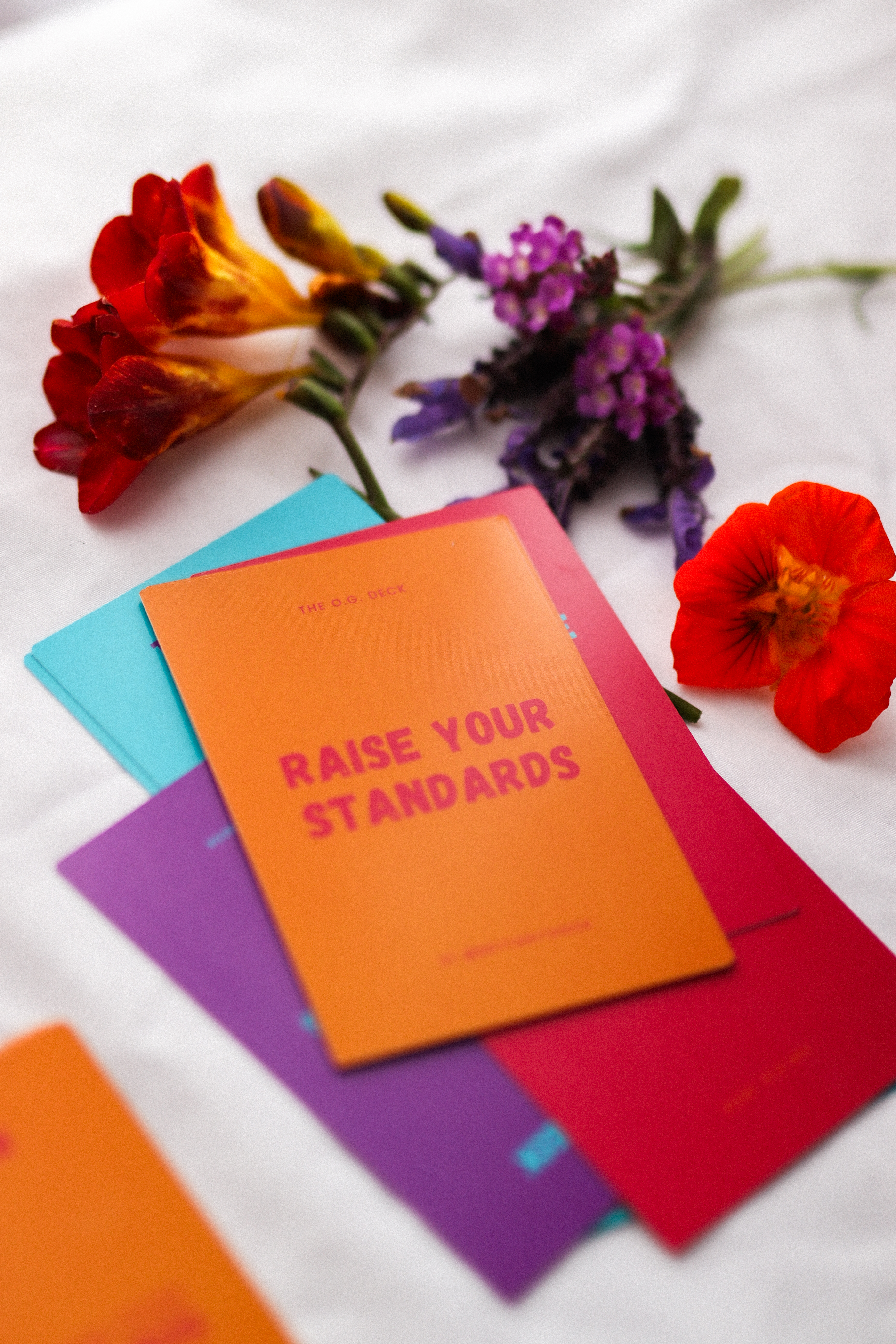 Multicoloured affirmation cards next to flowers