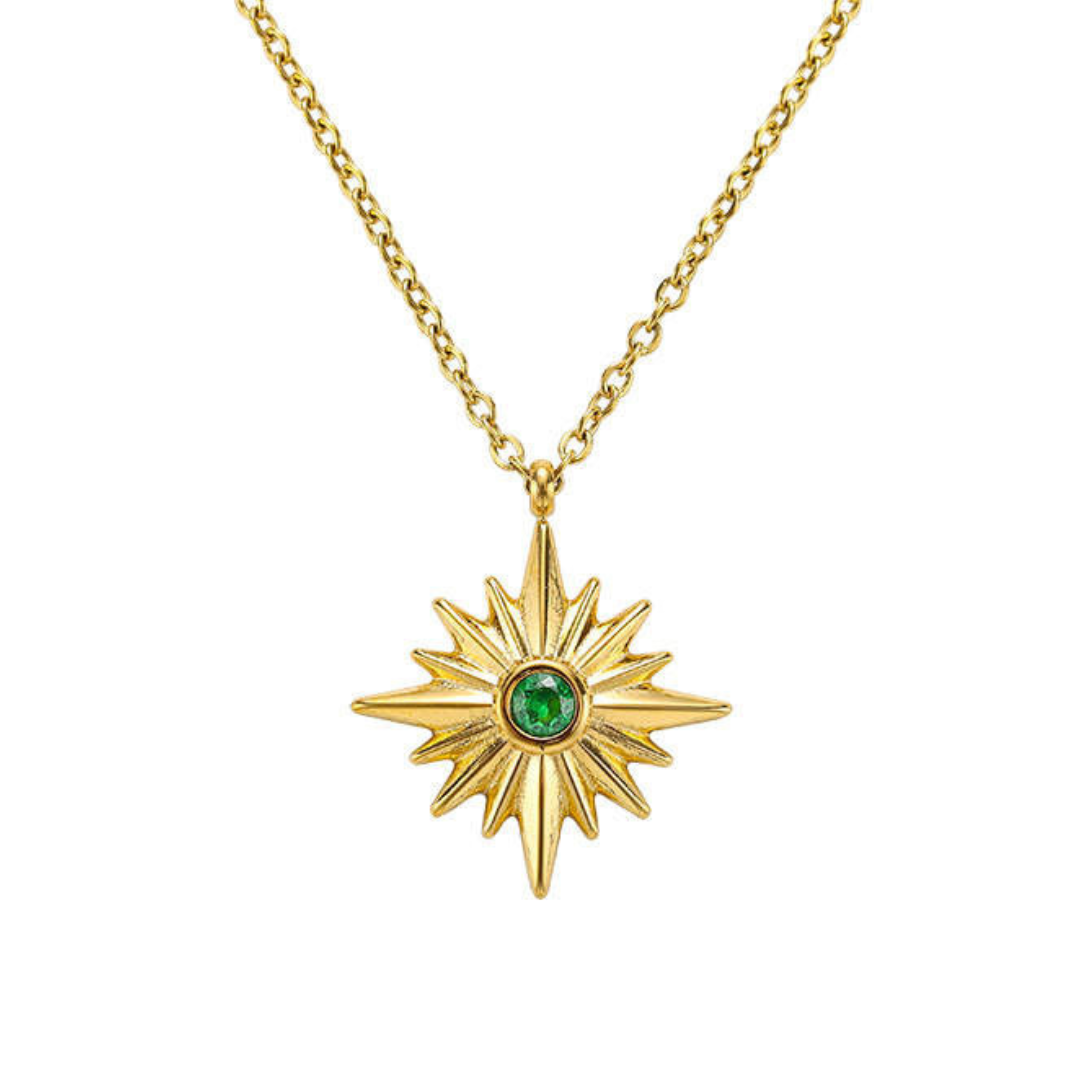 Gold chain neckland with green jewel inside of gold charm