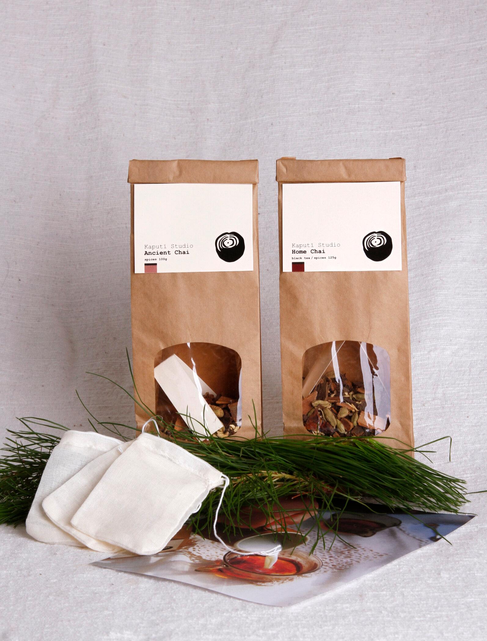 Two brown bags of loose leaf tea in front of a white background