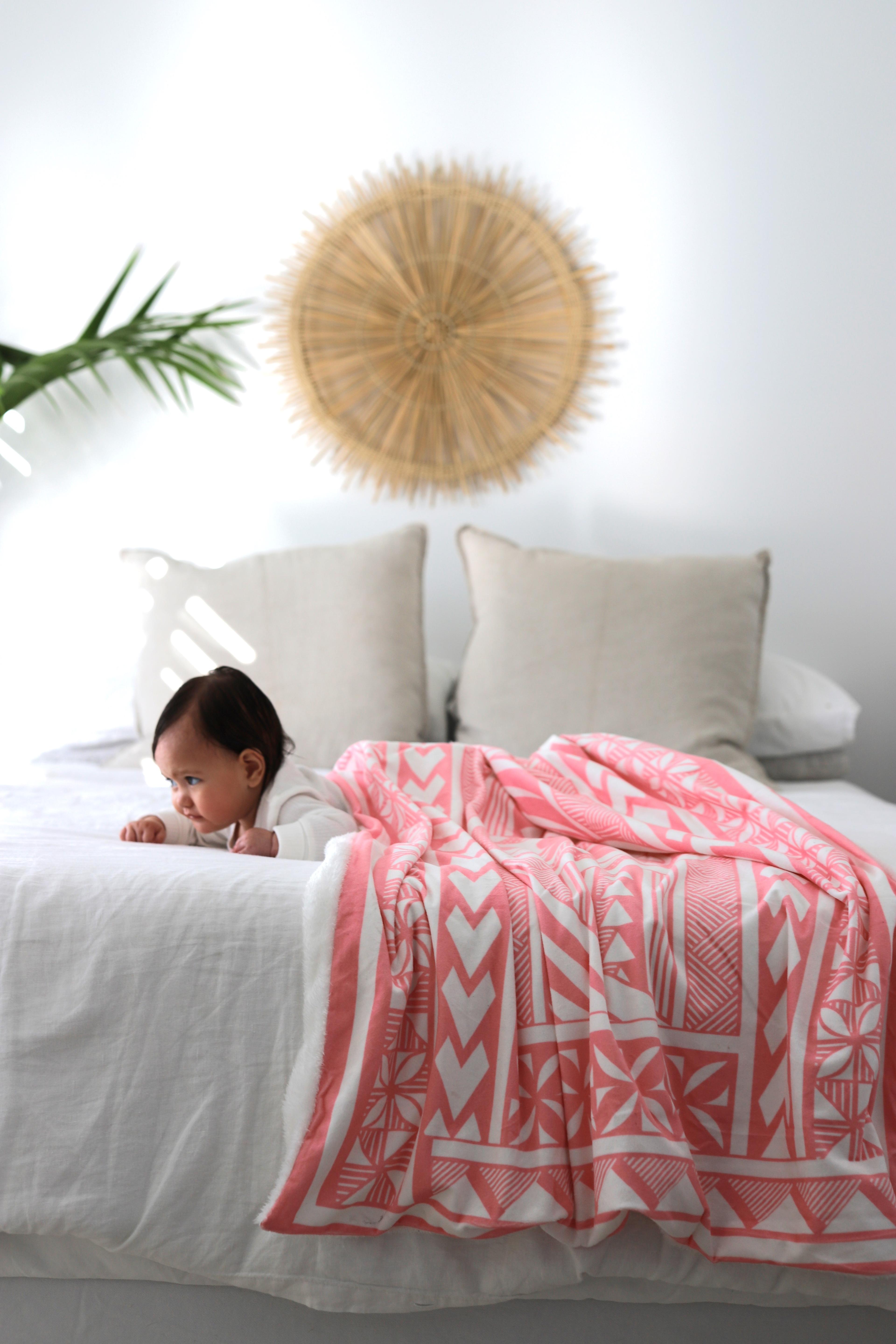 Baby wearing a pink mink blanket