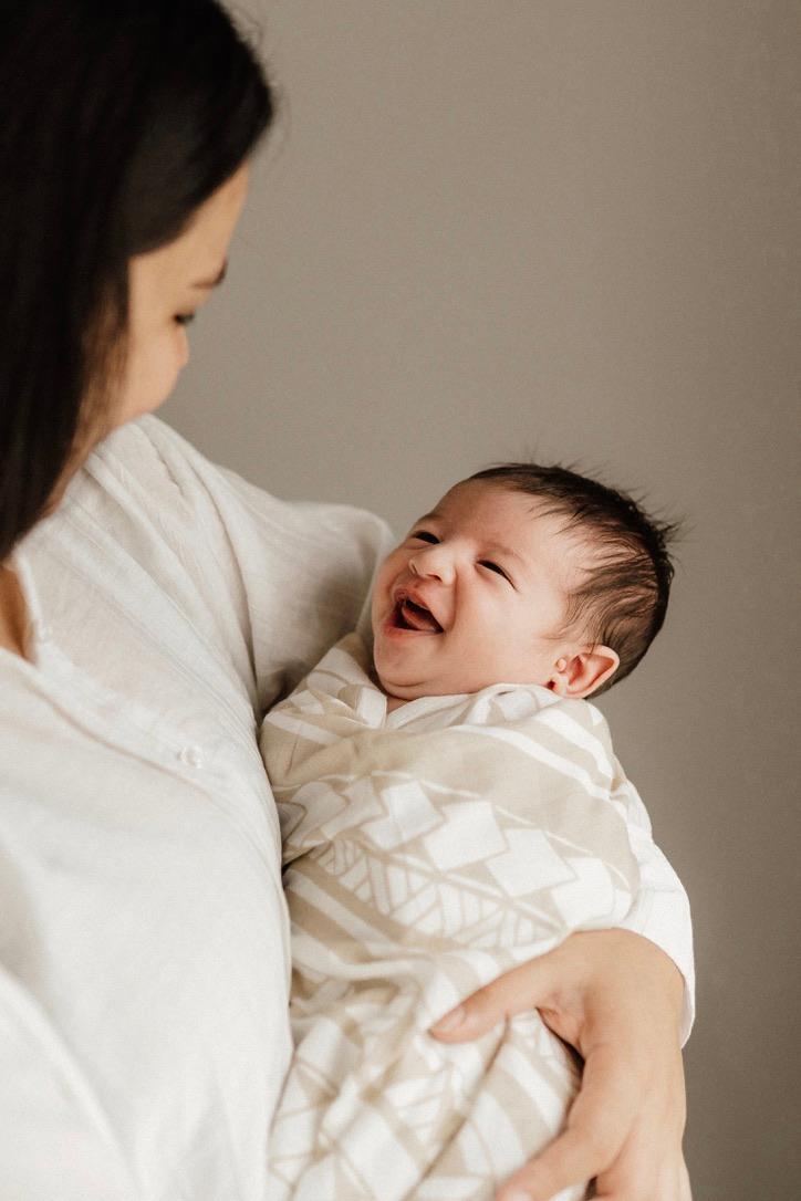 Mother and laughing baby wrapped in polynesian inspired baby wrap