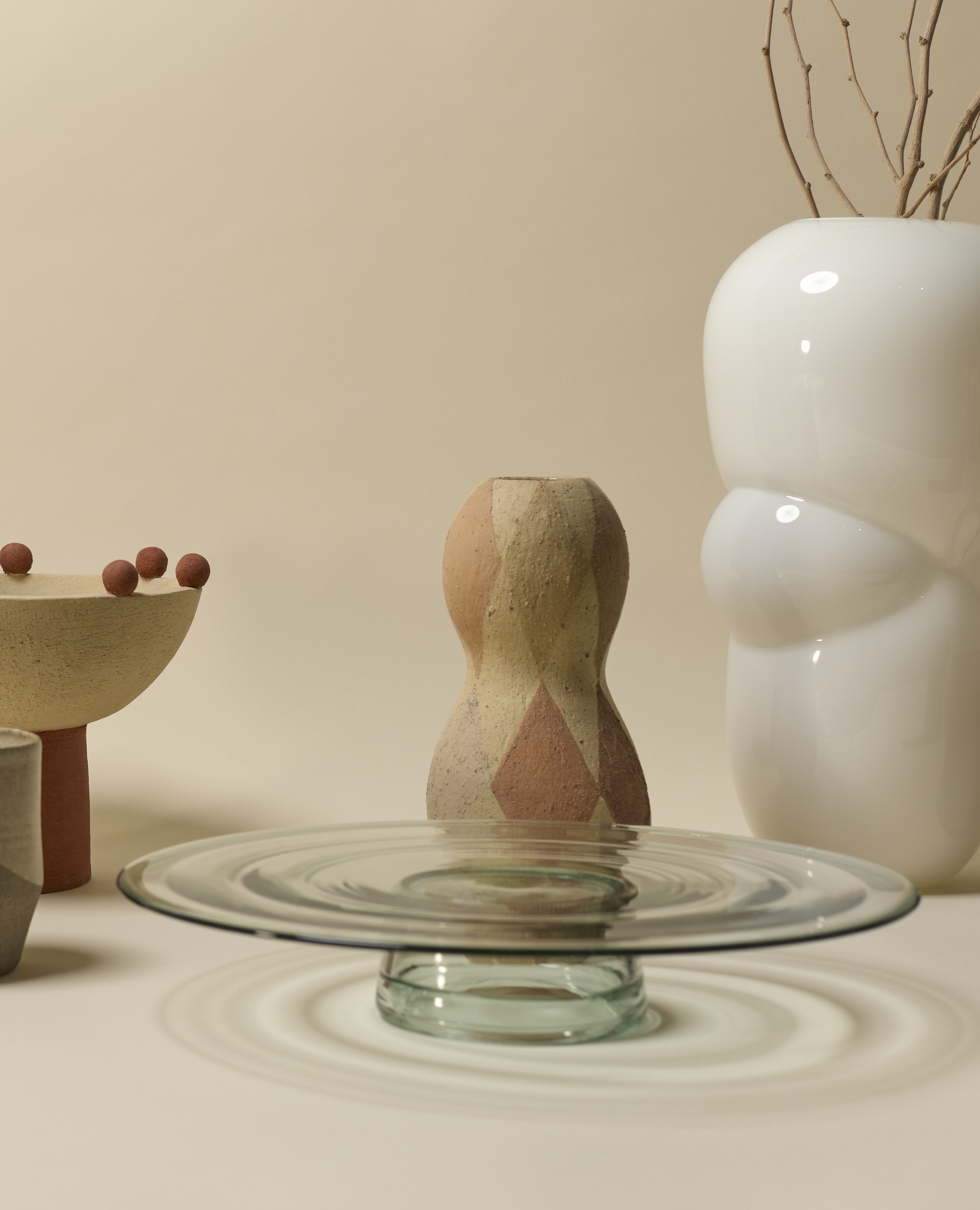 Assortment of vases and bespoke homewares in front of a beige background